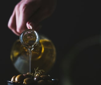 a person pouring olives into a bowl of olives